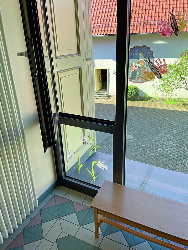 Geöffnetes Fenster mit Aufstiegshilfe in einer Kita